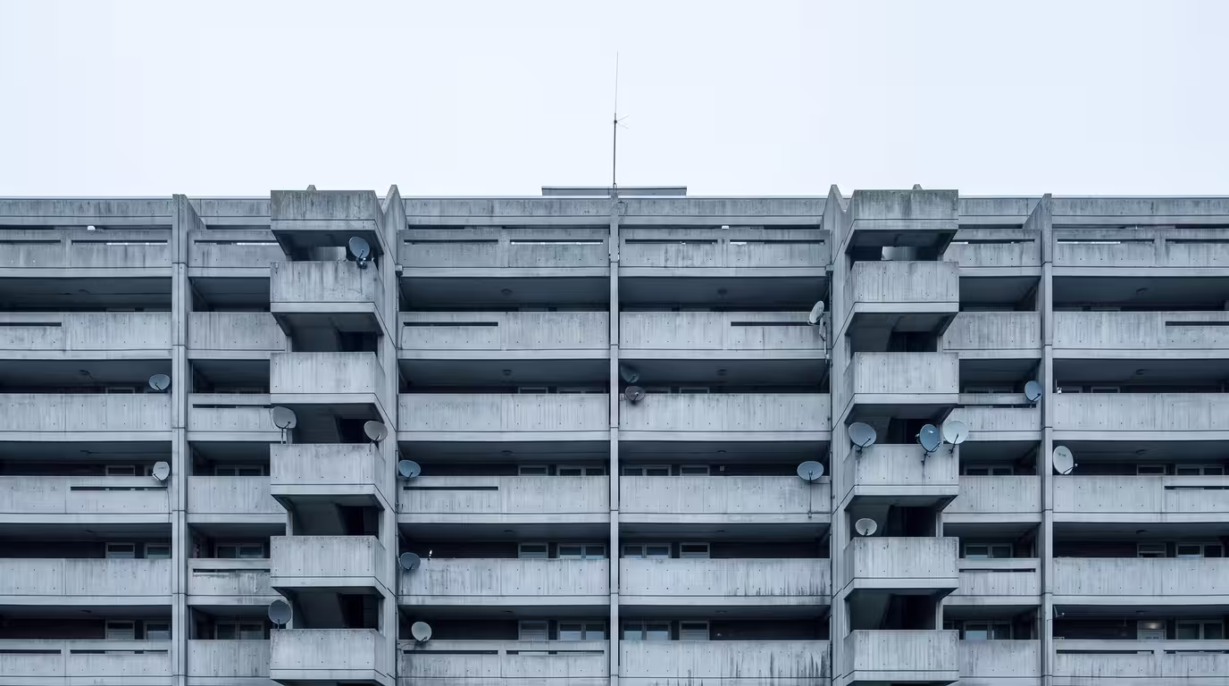 A 1970s London council estate with a thin aerial on the rooftop under a grey sky