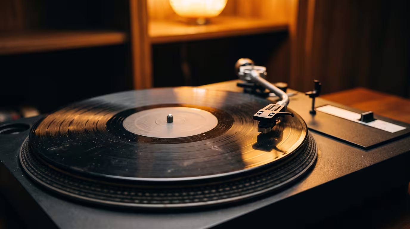 Close-up of a needle on a dusty, worn vinyl record in warm lamplight